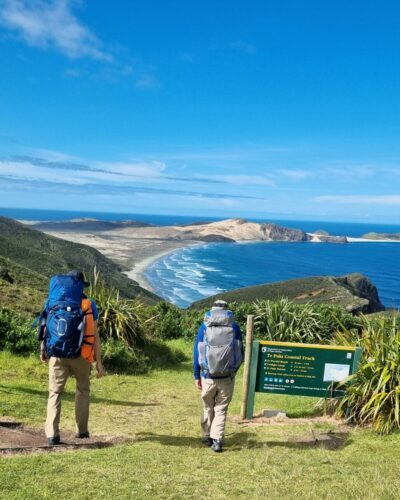 Two men walking the Te Paki Coastal track in New Zealand