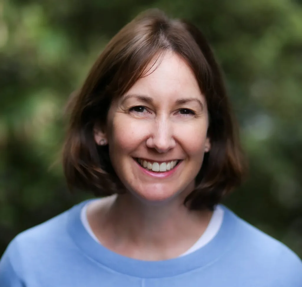 European woman with brown hair smiling at the camera