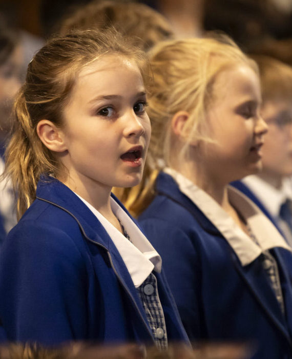 Primary school girl singing at carol service