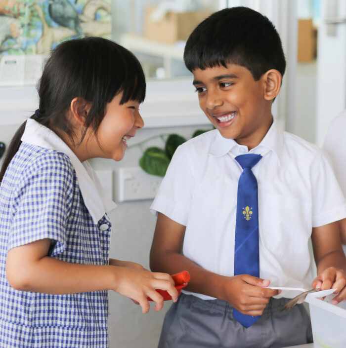 Two young primary school friends laughing together