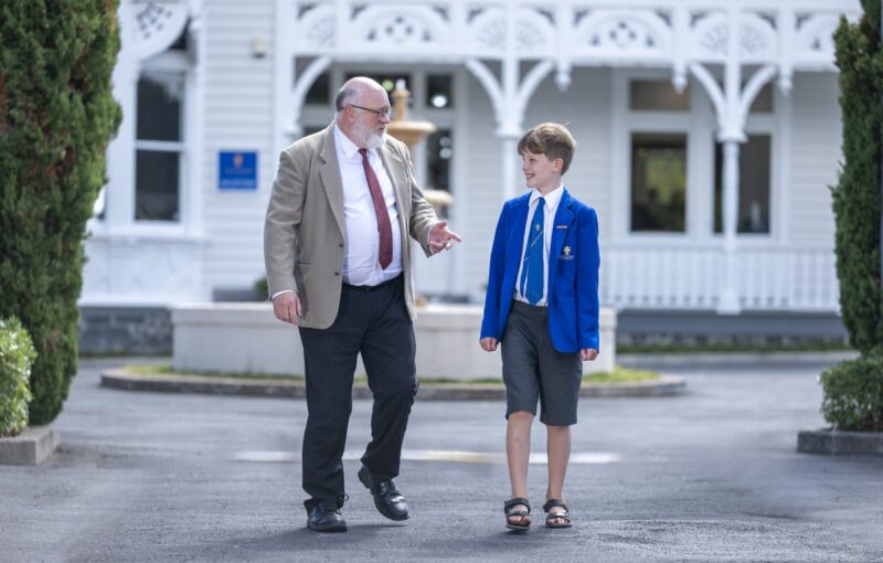 Older man and young male student walking together