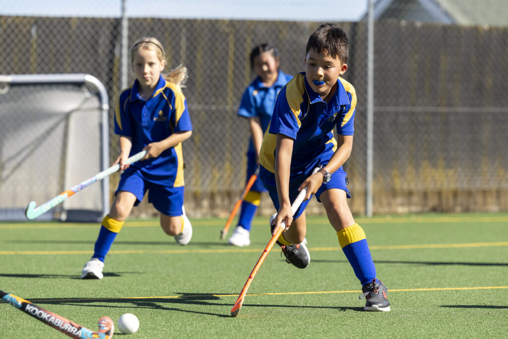 young students playing hockey