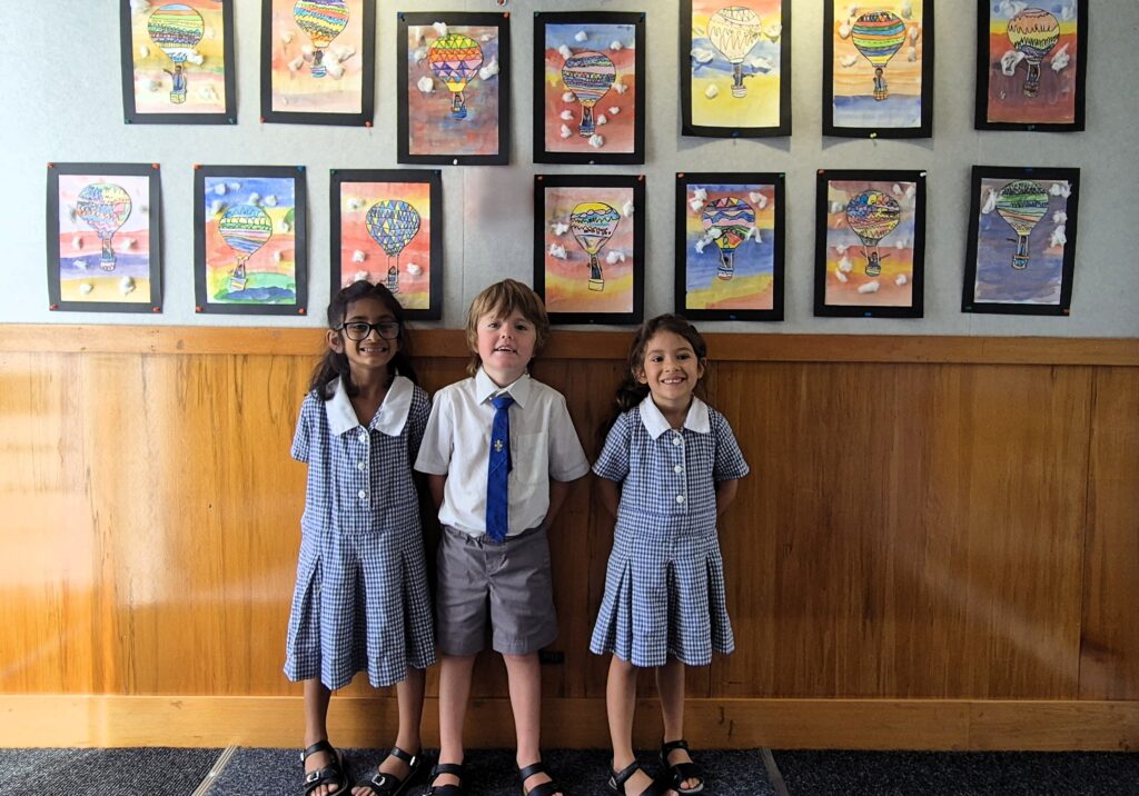 Girls and boy under artwork