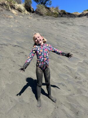 Girl covered in black sand