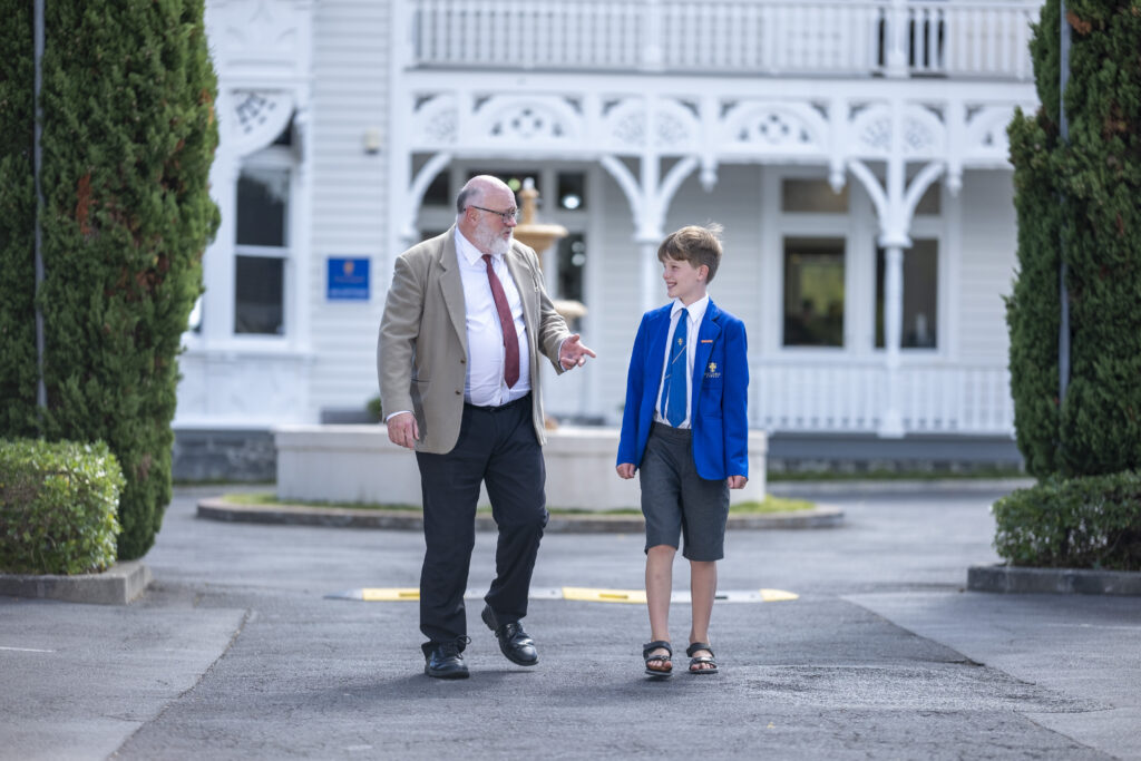 Male teacher and student walking and talking with respect