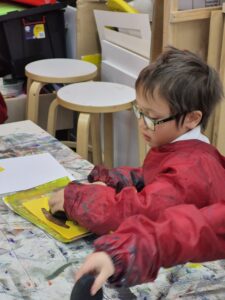 Young boy making art stamps