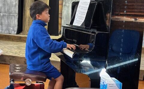 Young boy plays piano