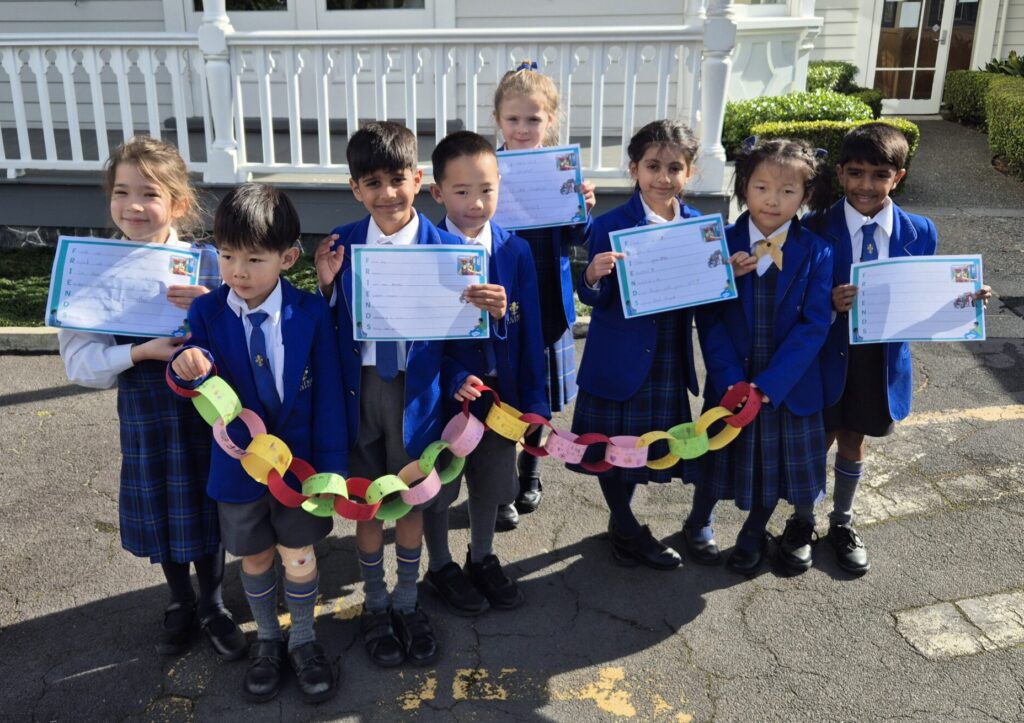 Children standing together holding colourful links