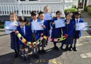 Children standing together holding colourful links