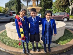 Children stand together in front of a fountain