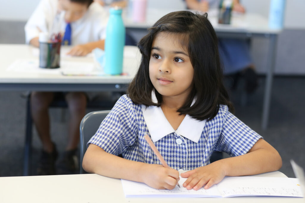 Young schoolgirl writing at a desk