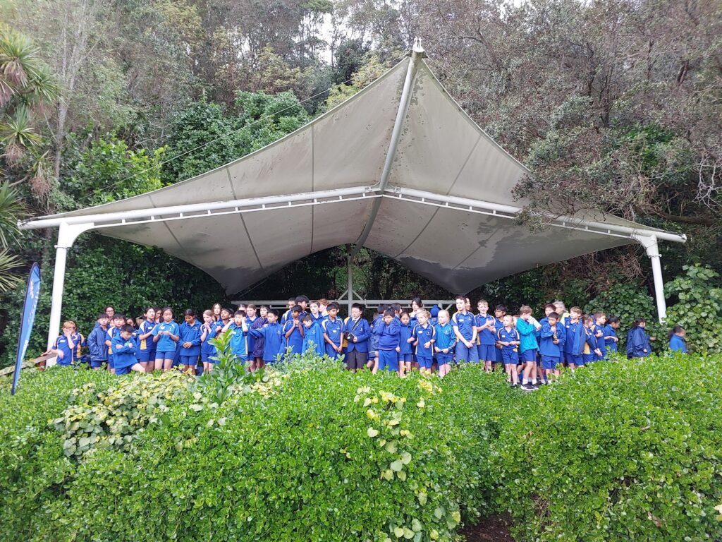 a group of children in blue uniforms standing in front of a white tent