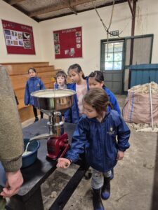 Young children using a milk churn