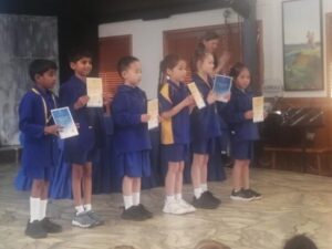 Young primary school children receive prizes on stage