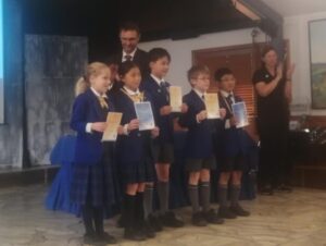 Young primary school students receive awards on stage