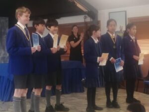 Young primary school students receive awards on stage