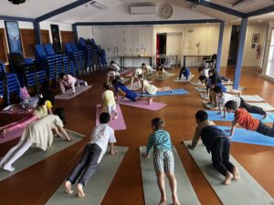 Young children practise yoga in school hall