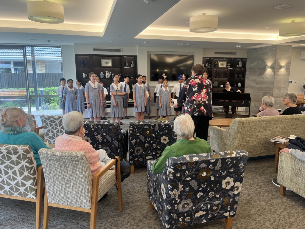 Group of student ssinging songs for the elderly.