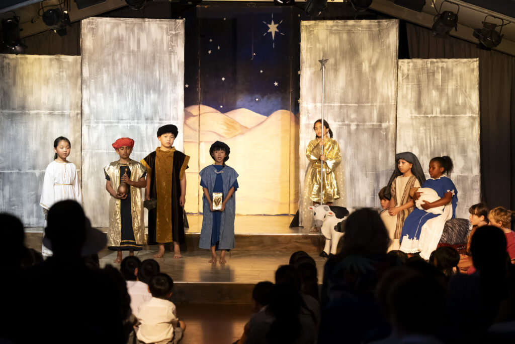 Group of children standing on a stage in costumes