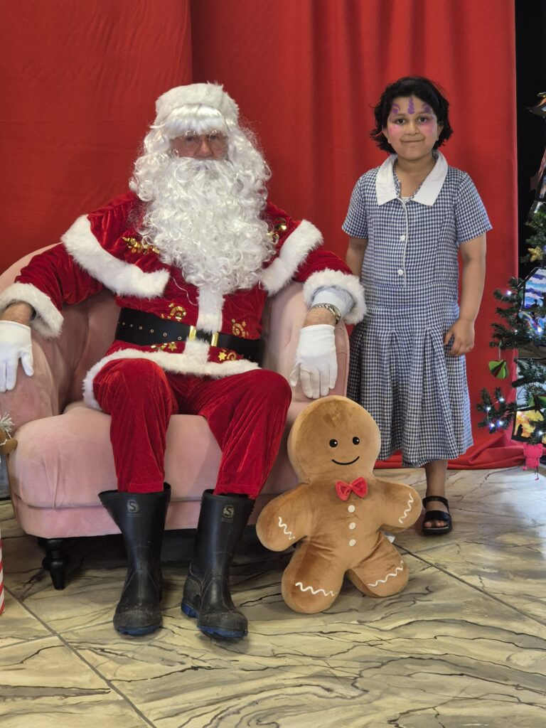 Young girl standing next to Santa Claus