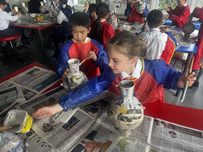 School students doing papier mache