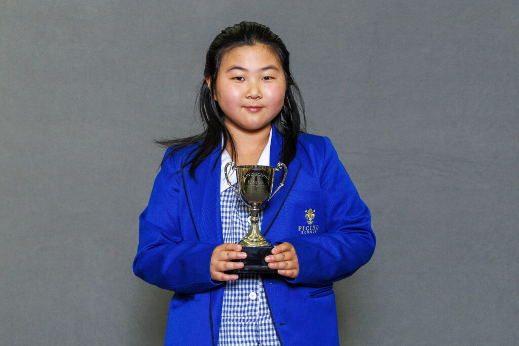 Girl in blue blazer holidng a trophy