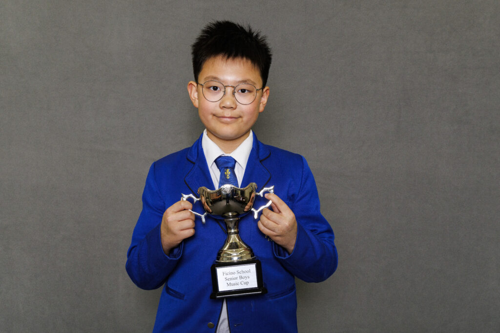 Boy in blue blazer holidng a trophy