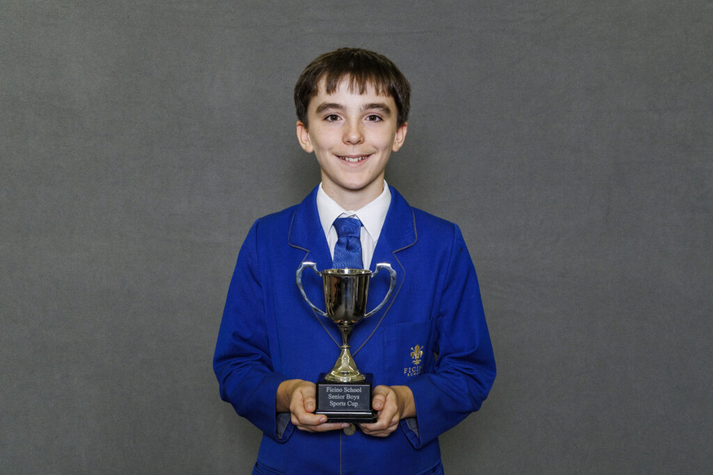 Boy in blue blazer holidng a trophy