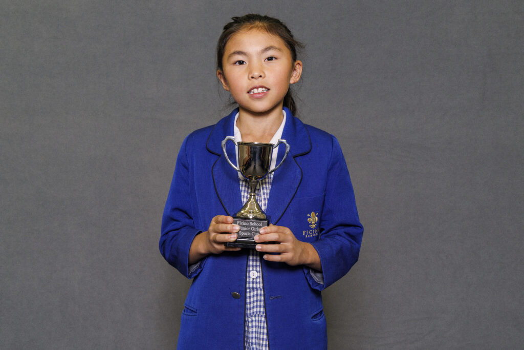 Girl in blue blazer holidng a trophy