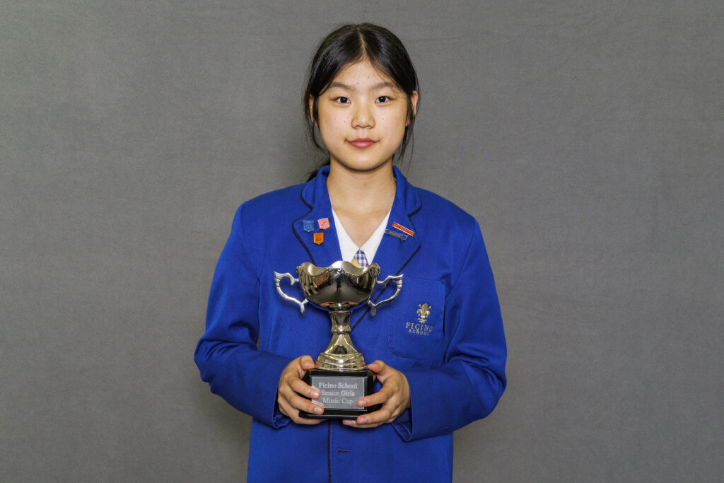 Girl in blue blazer holidng a trophy