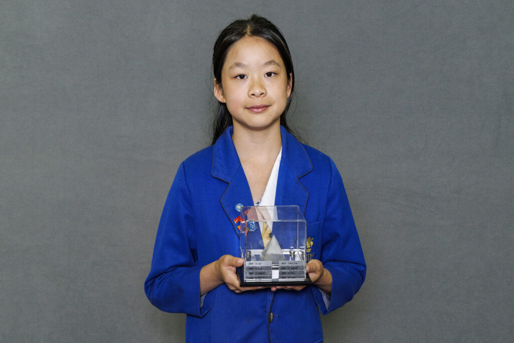 Girl in blue blazer holidng a trophy