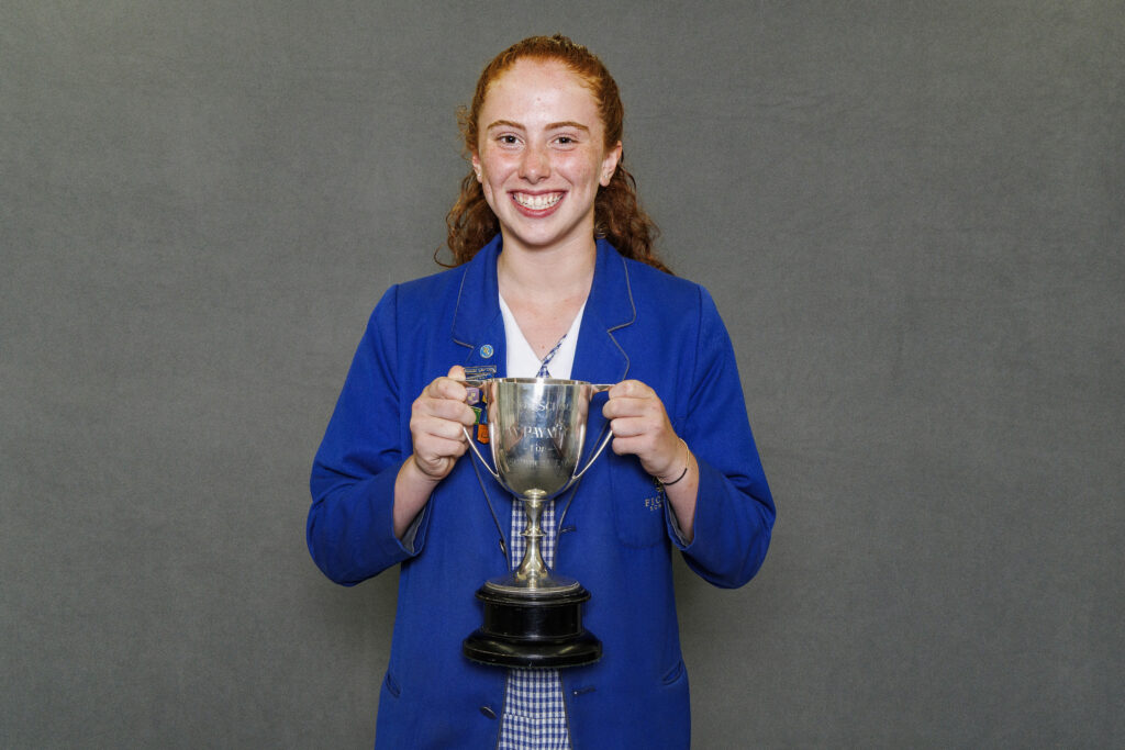 Girl in blue blazer holidng a trophy