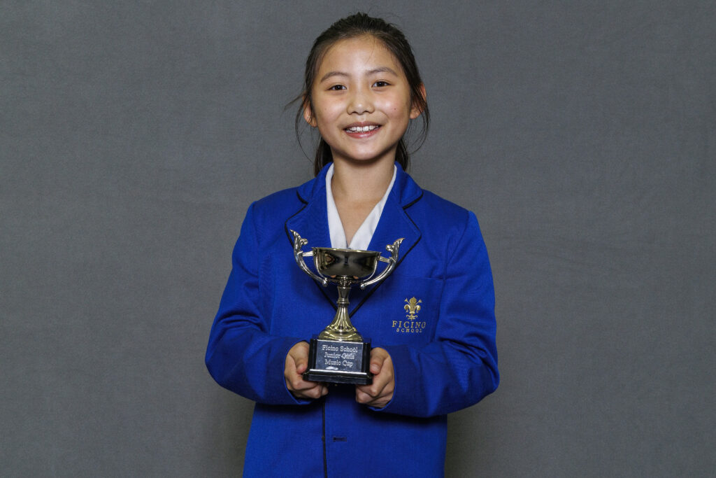 Girl in blue blazer holidng a trophy