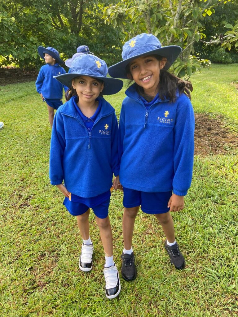 Two school girls wearing blue sunhats