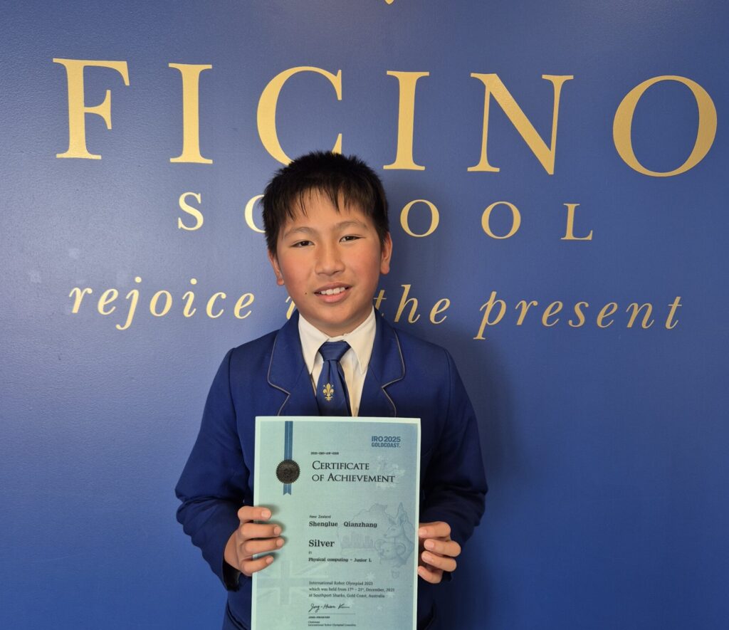 A schoolboy wearing a blazer holding a cetificate