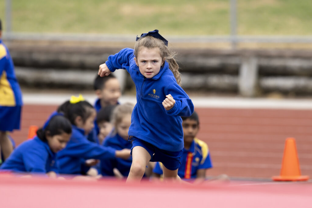 Schoolgirl in blue on a running track