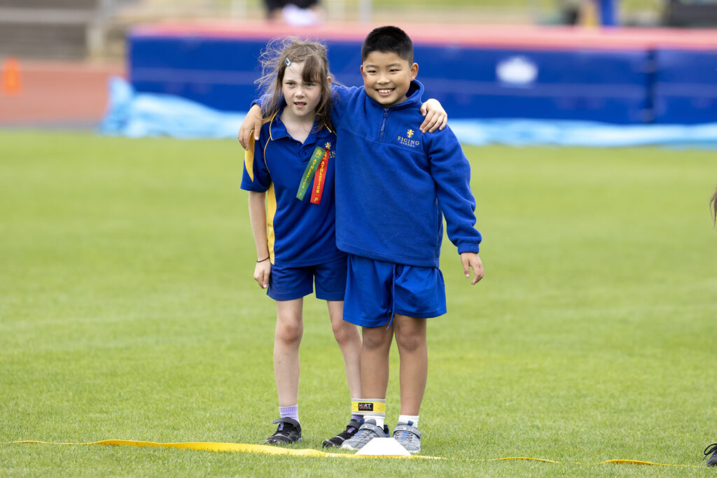 Boy and gitl in blue shorts with their arm around each other