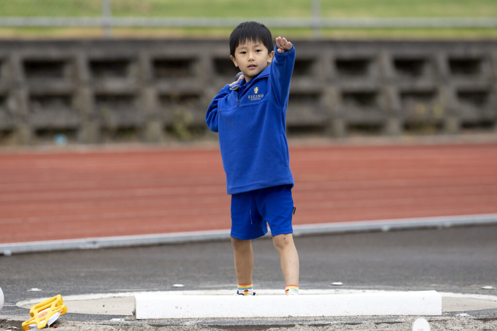 Young Chinese boy throwing a ball