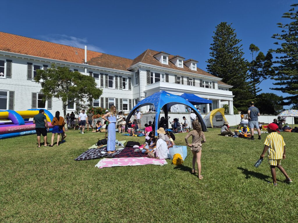 Village fair taking place in front of a large white house