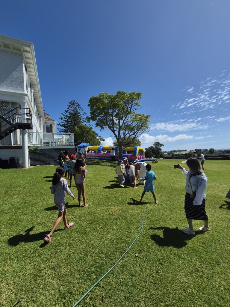 People standing on a lawn with blue sky above