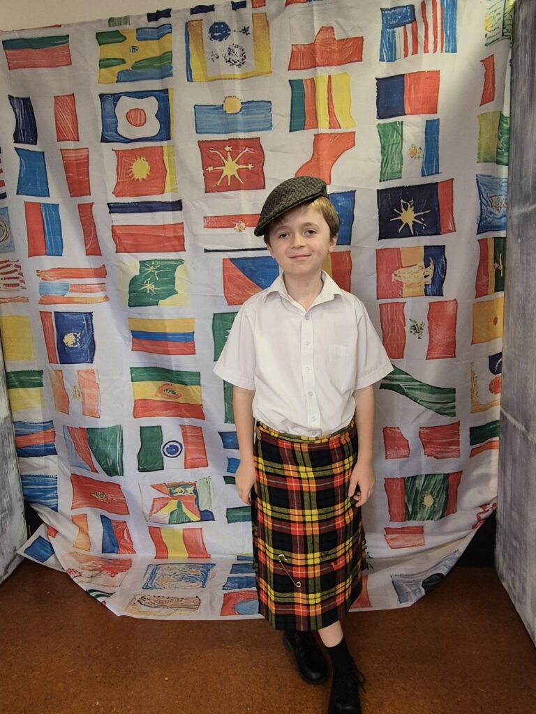 Young boy wearing a kilt and flat cap