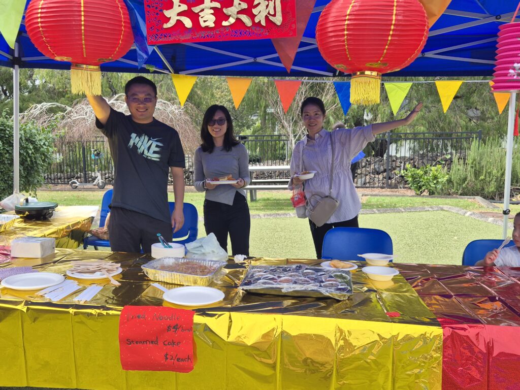 Three Chinese people standing in a gazebo decorated with Chinese decorations