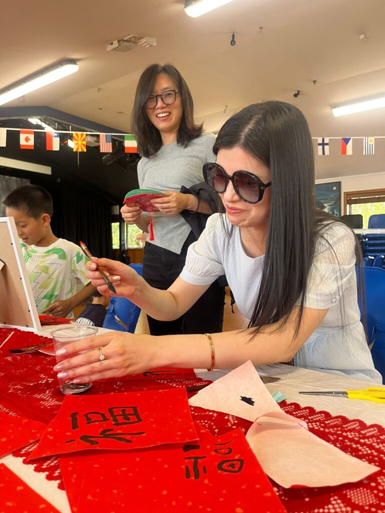 A Chinese woman wearing sunglasses doing calligraphy
