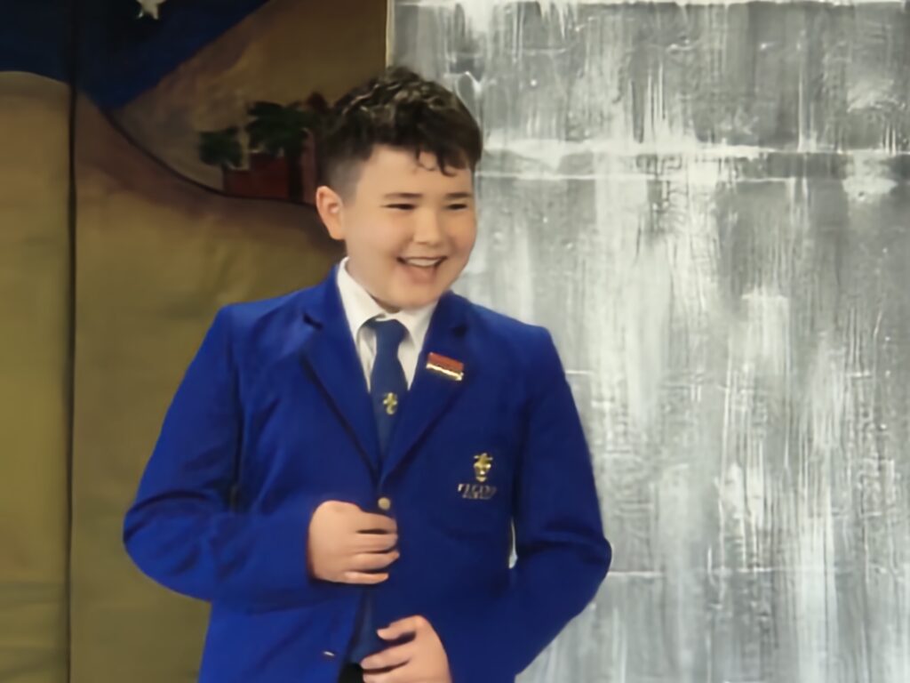 Boy in a blue blazer smiling