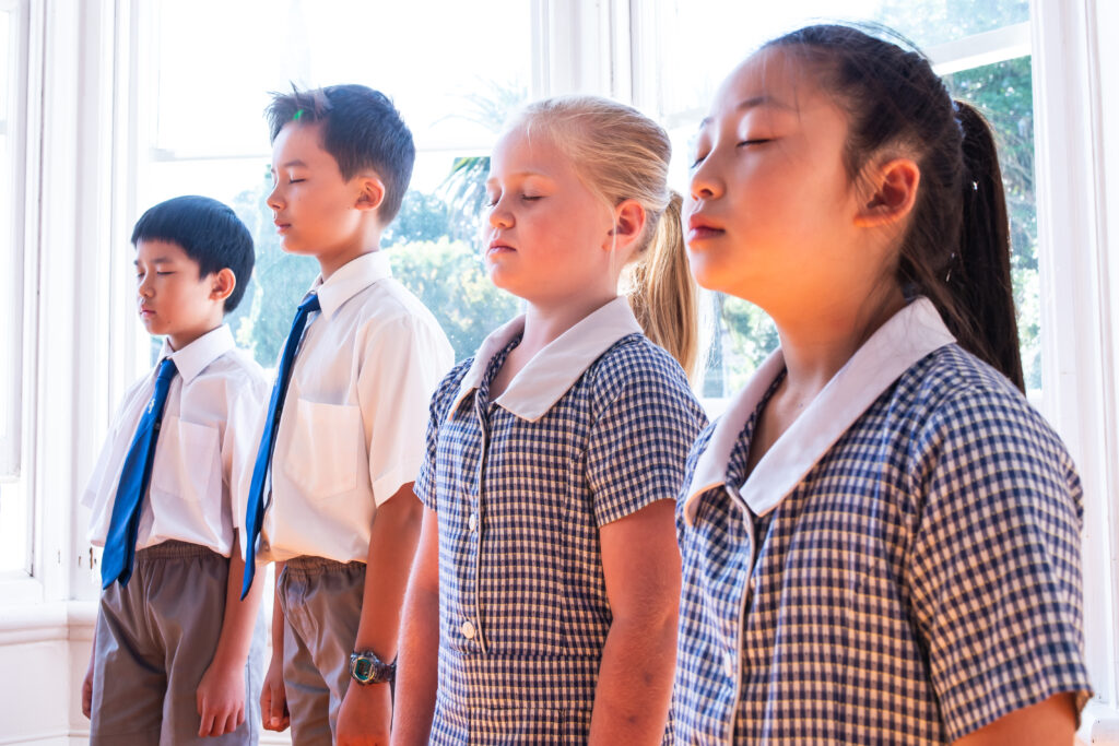 A group of children practising mindfulness