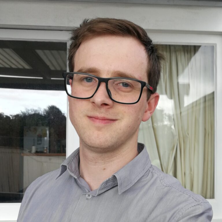 Head shot of a young man wearing glasses and a business shirt